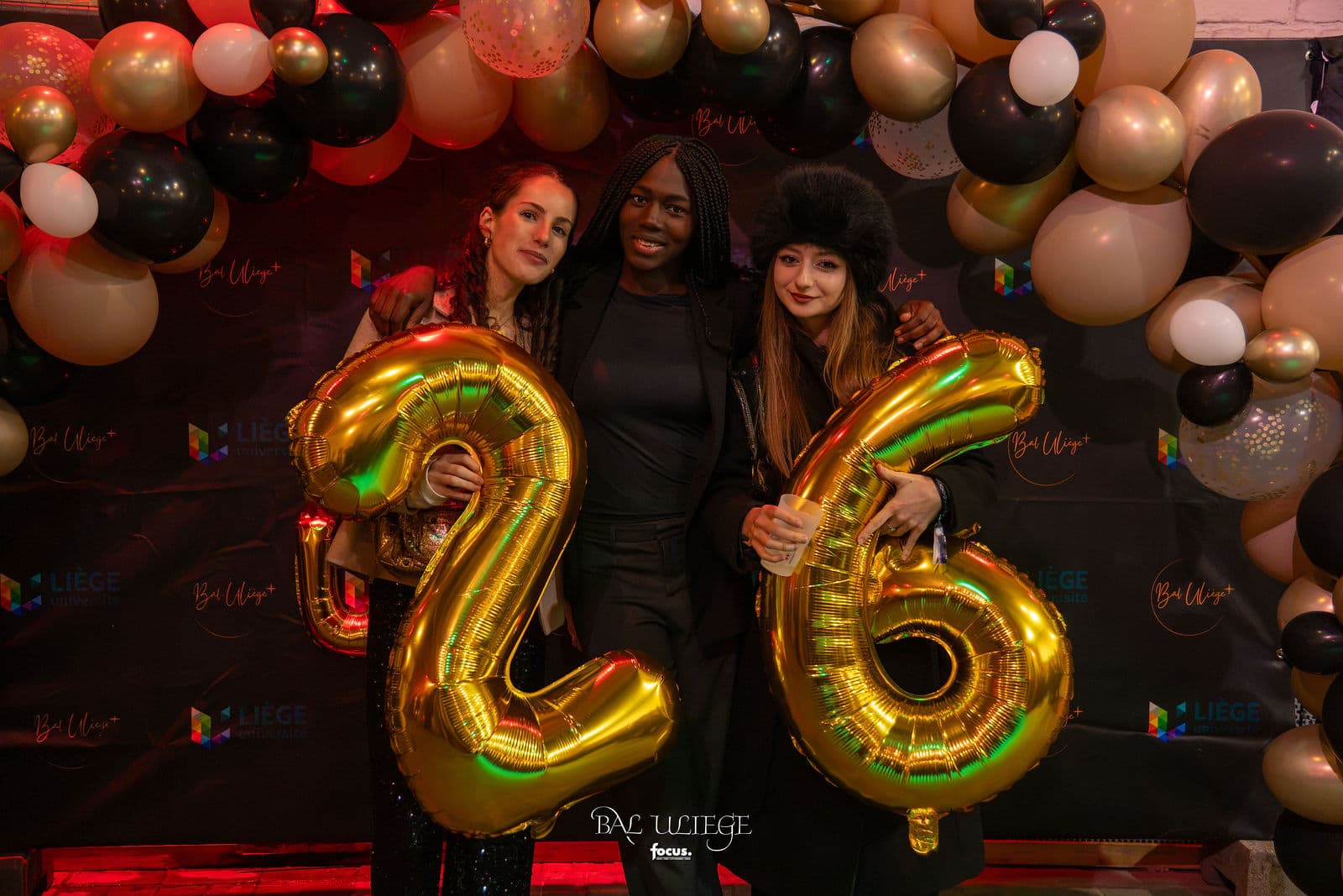 Trois invitées derrière les ballons dorés « 26 »